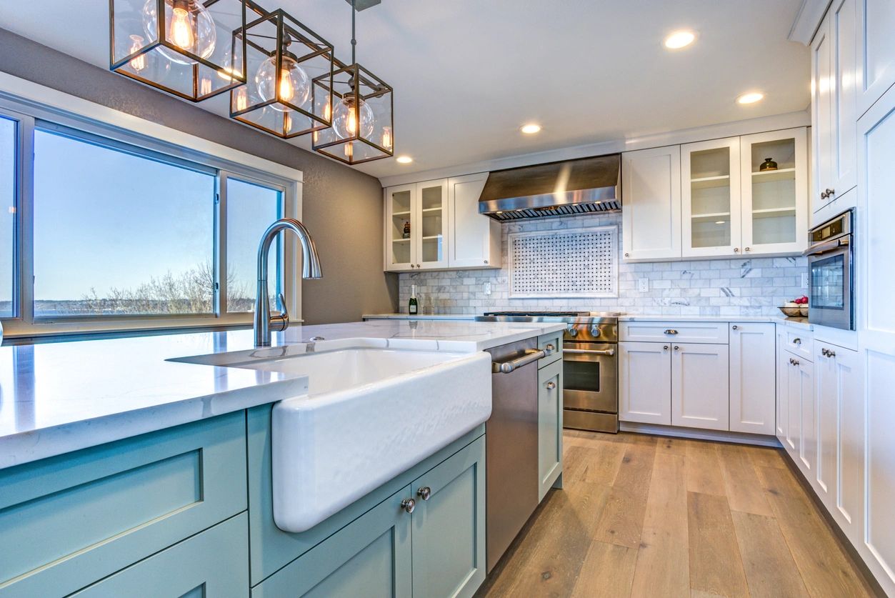 Modern kitchen with farmhouse sink and pendant lighting.